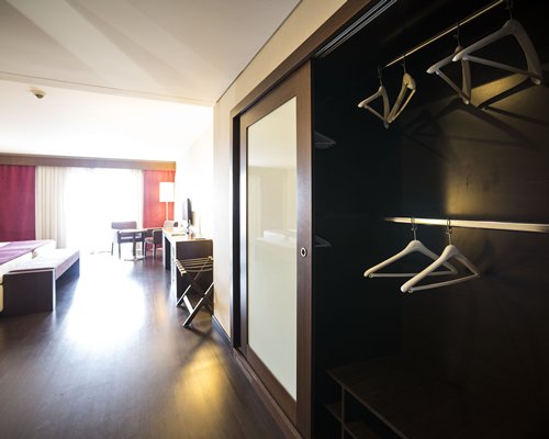 A well furnished bedroom with television and an outside view.