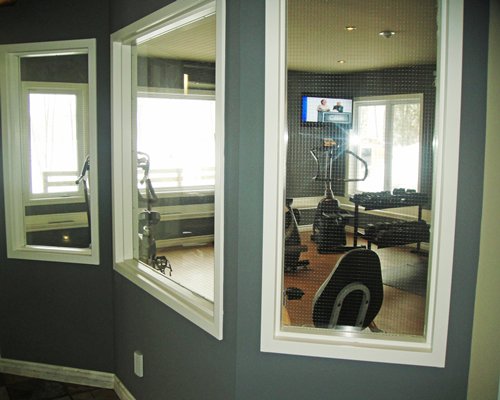 A well equipped indoor fitness center with an outside view.