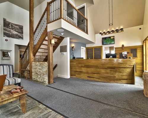 A well furnished reception area with a staircase and indoor balcony.