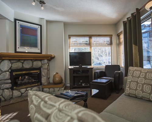 A well furnished living room with a television and fire place.