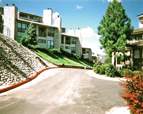 Street view of multi story resort units alongside landscaping.