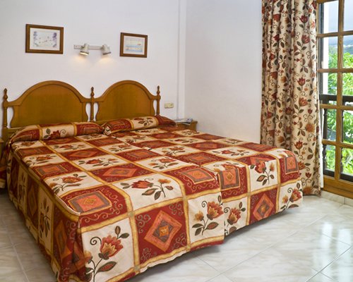 A well furnished bedroom with twin beds and outside view.