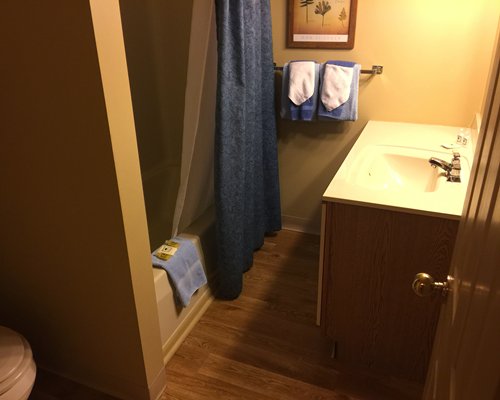 A bathroom with a single sink vanity and a bathtub.