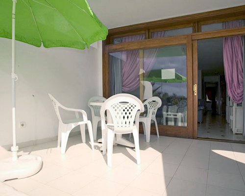 Outdoor patio with patio chairs and sunshade.