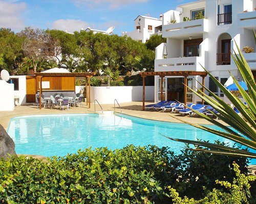An outdoor swimming pool with chaise lounge chairs.