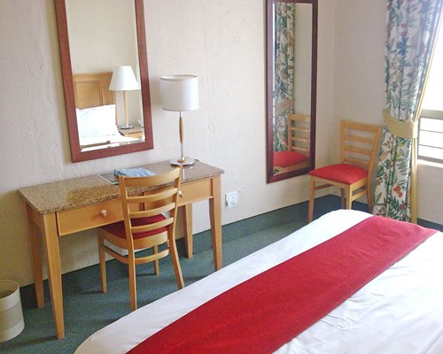 A well furnished bedroom with king bed and patio furniture.
