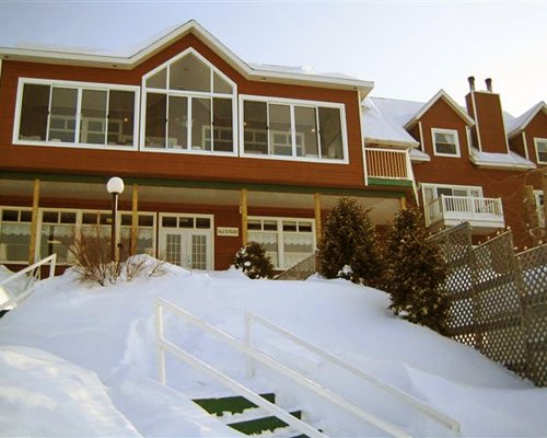 An exterior view of multi story resort units covered in snow.