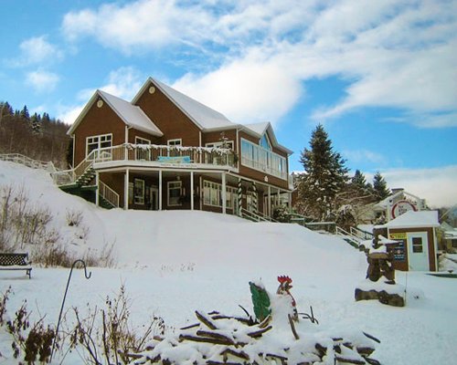 Exterior view of Chalets Sur Le Fjord resort covered by snow.
