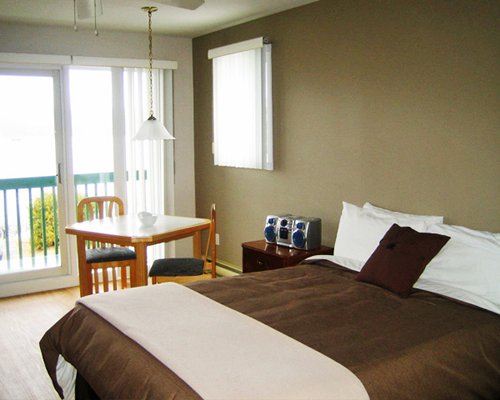 A well furnished bedroom with a two seater dining table and an outside view.