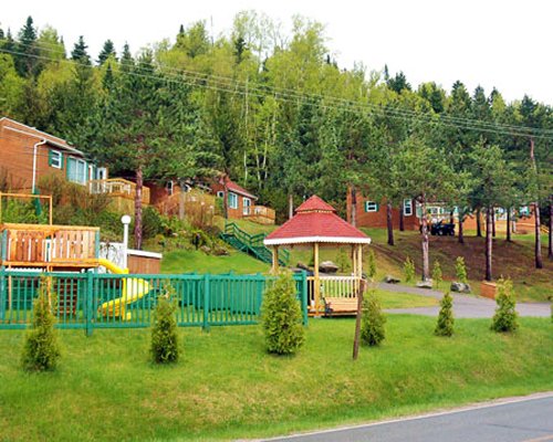 Outdoor kids playscape surrounded by wooded area.