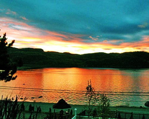 A view of the lake alongside the hills at sunset.