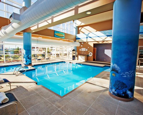 Indoor swimming pool with chaise lounge chairs.