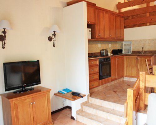 Living room with television and open plan kitchen.