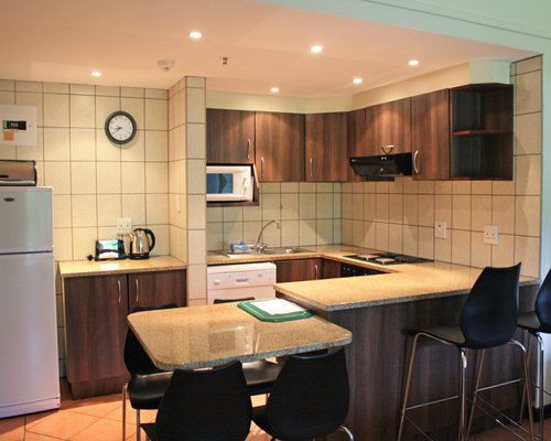 An open plan kitchen with breakfast bar and dining area.