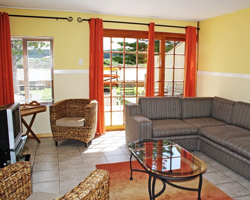 A well furnished living room with sofas television and an outside view.
