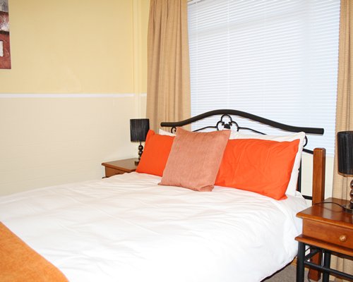 A well furnished bedroom with two lamps.