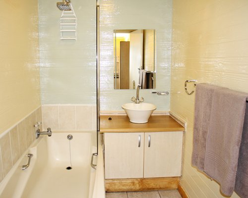 A bathroom with a shower bathtub and single sink vanity.