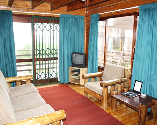 A well furnished living room with television and an outside view.