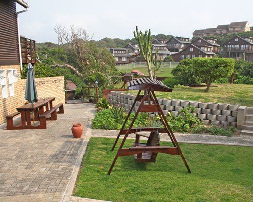 Scenic outdoor picnic area with a wooden swing and sunshade.
