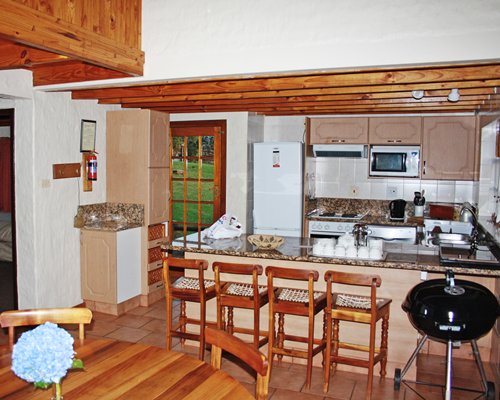 A well furnished dining area alongside kitchen with a breakfast bar.