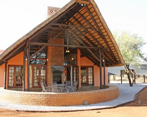 An exterior view of a resort unit alongside patio furniture.