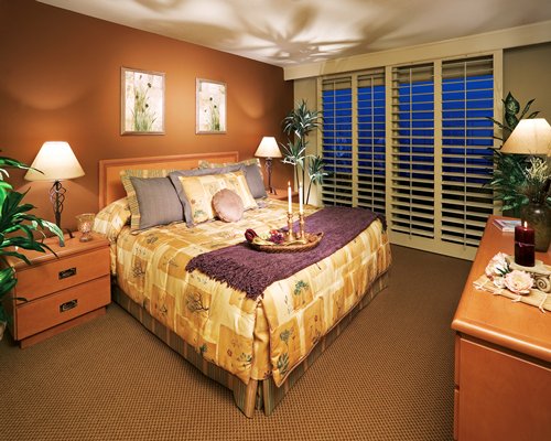 A well furnished bedroom with a king bed and an outside view.