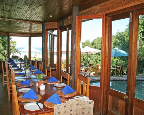 An indoor fine dining restaurant with outside view of outdoor swimming pool.