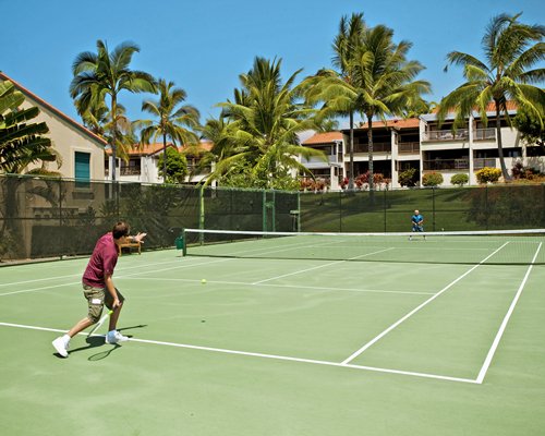 An outdoor tennis court alongside resort units.