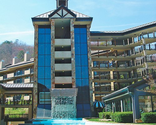 An exterior view of multi story resort units with water feature.