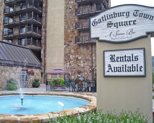 A signboard of the Gatlinburg Town Square By Exploria Resorts alongside a swimming pool.