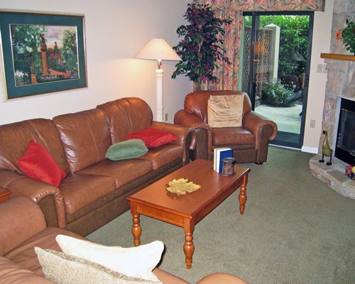 A well furnished living room with fireplace and patio.