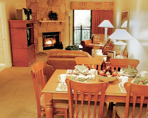 An open plan living and dining area with a television and a fireplace.