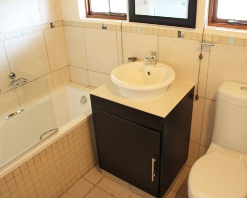 A bathroom with bathtub and closed sink vanity.