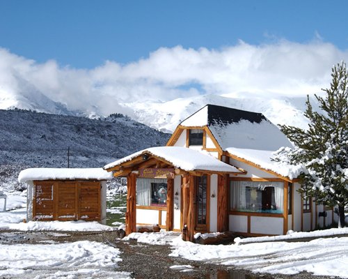 An exterior view of the Catedral Ski Village resort covered in snow.