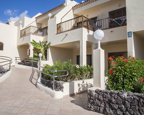 An outdoor swimming pool with chaise lounge chairs alongside the resort units.