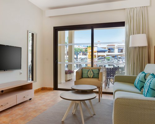 A well furnished living room with a television bedroom and outside view.