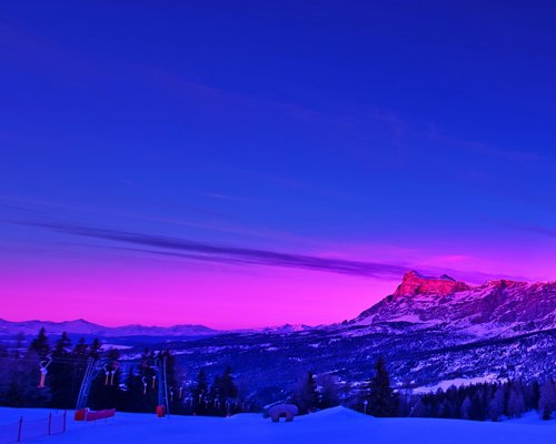 A scenic view of the snowy mountain at dusk.