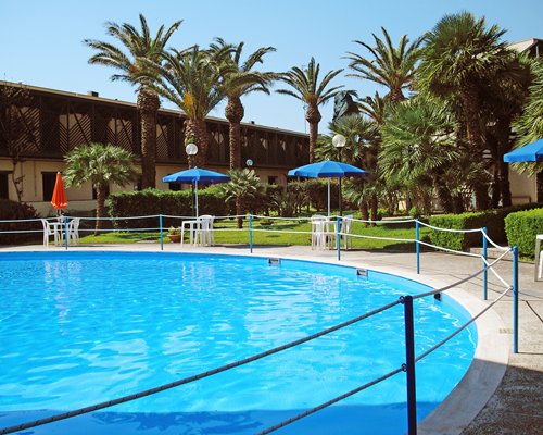 An outdoor swimming pool alongside resort units and landscaping.