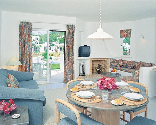 An open plan living and dining area with a television and patio.