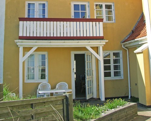 Entrance to a unit at Skagenklit with balcony and patio chairs.