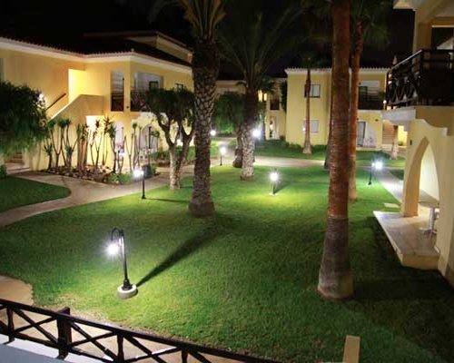Exterior view of multiple unit balconies at Malama Beach Club at dusk.