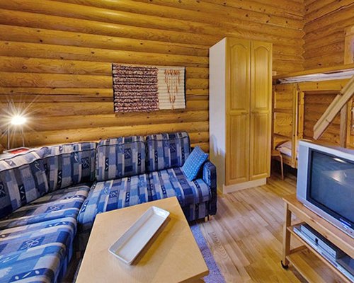 A well furnished living room with a television and bunker beds.