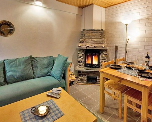 An open plan living room dining area and fire in the fireplace.