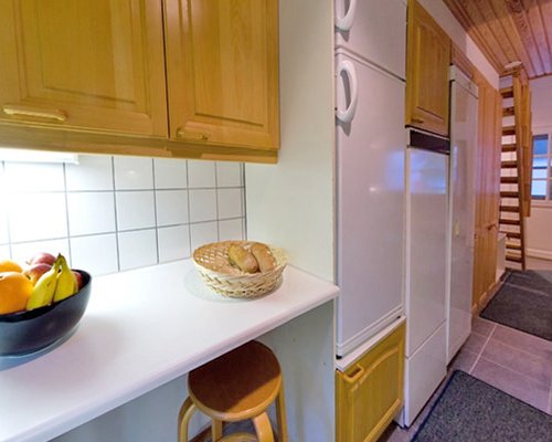 A well equipped kitchen with a wooden stairway.