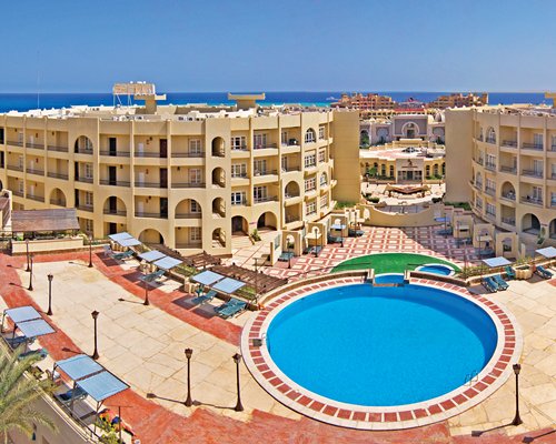 A scenic exterior view of resort with pool patio and the Red Sea.