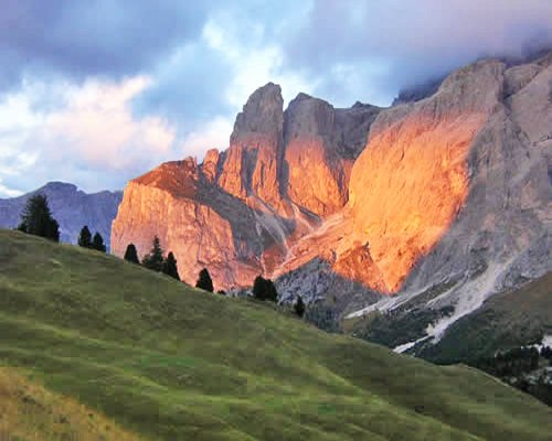 A scenic landscape alongside mountains during winter at dusk.