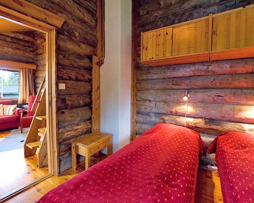 A wooden themed bedroom with two beds.