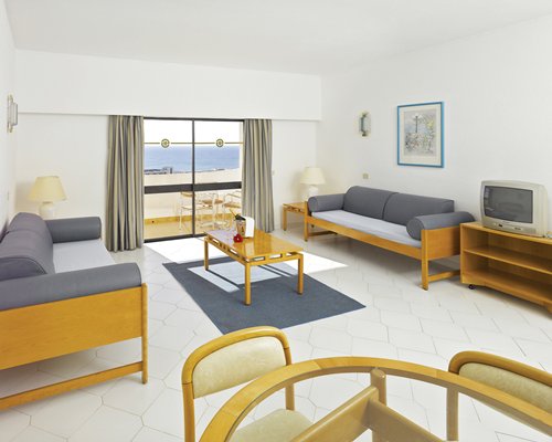A well furnished living room with television and balcony.