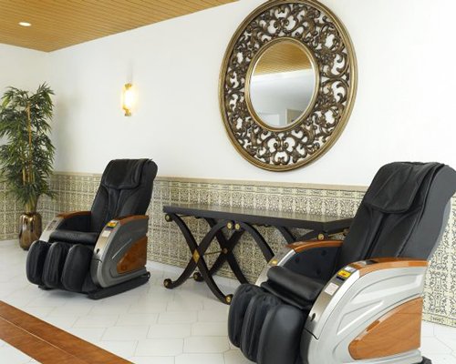 A well furnished indoor room with two massage chairs.