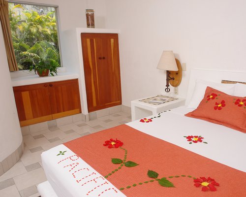 A well furnished bedroom with a queen bed and an outside view.